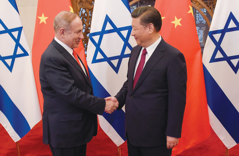  THEN-PRIME MINISTER Benjamin Netanyahu and Chinese President Xi Jinping shake hands ahead of talks in Beijing, in 2017. ‘Beijing is not a friend. It is time to pivot away from Beijing,’ say the writers.  (credit: Etienne Oliveau/Reuters)