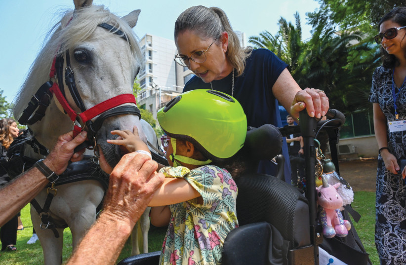  MICHAL HERZOG and (below) her husband, President Isaac Herzog, join in pony petting therapy with a five-year-old child at Beit Loewenstein rehabilitation hospital. (credit: KOBI GIDEON/GPO)