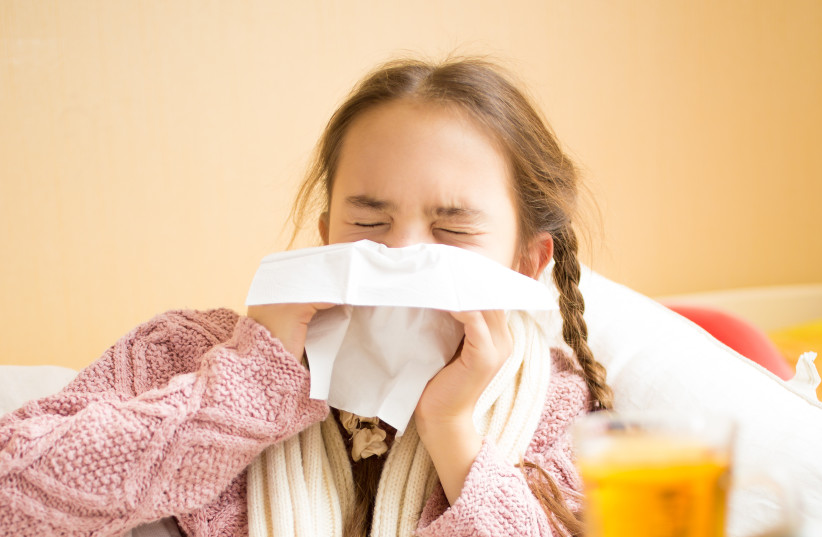  Illustrative photo of girl blowing her nose into a tissue (photo credit: INGIMAGE)