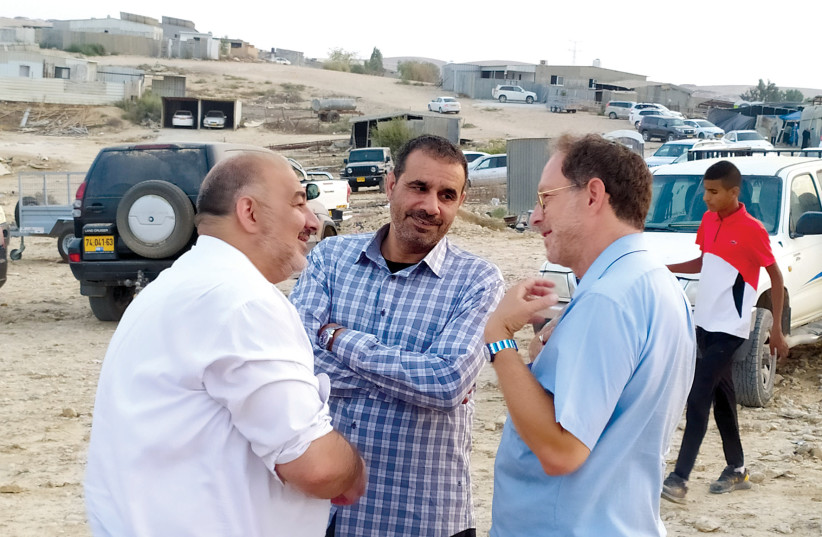  Dr. Mansour Abbas and Dr. Mohammed al-Nabari outside the tent of mourning for al-Harumi at Segev Shalom. ‘Now that Said is gone, it is your responsibility to work twice as hard to realize his solar vision,’ the Ra’am chairman tells the author. (credit: MICHA PRICE)