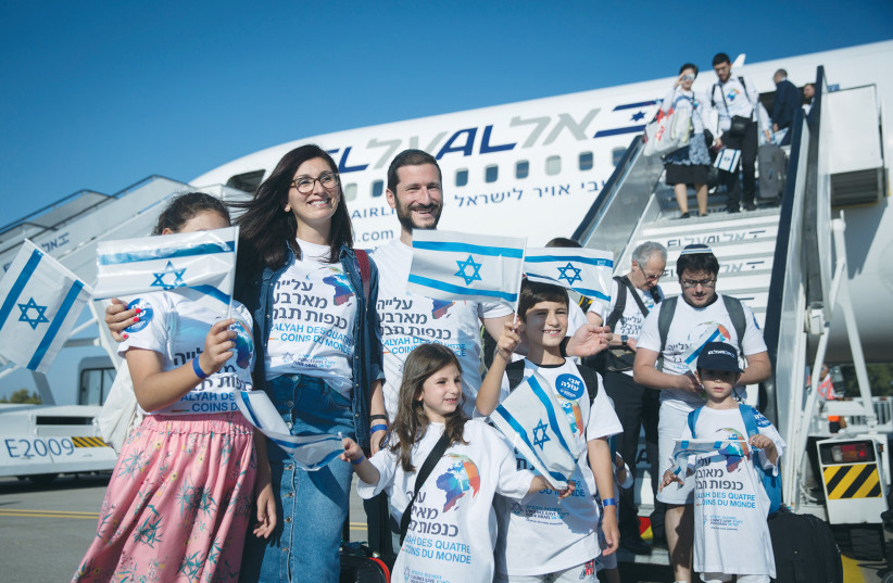  NEW IMMIGRANTS from France arrive at Ben-Gurion Airport, in 2018. Their shirts read: ‘Aliyah from the four corners of the universe.’ (photo credit: MIRIAM ALSTER/FLASH90)