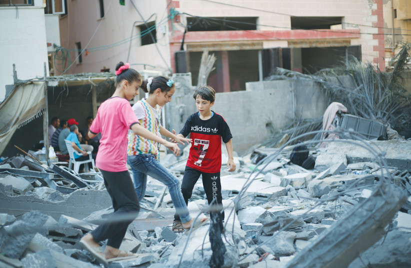  PALESTINIAN CHILDREN walk through the rubble of a destroyed building in Gaza City, following Operation Breaking Dawn (credit: ATTIA MUHAMMED/FLASH90)