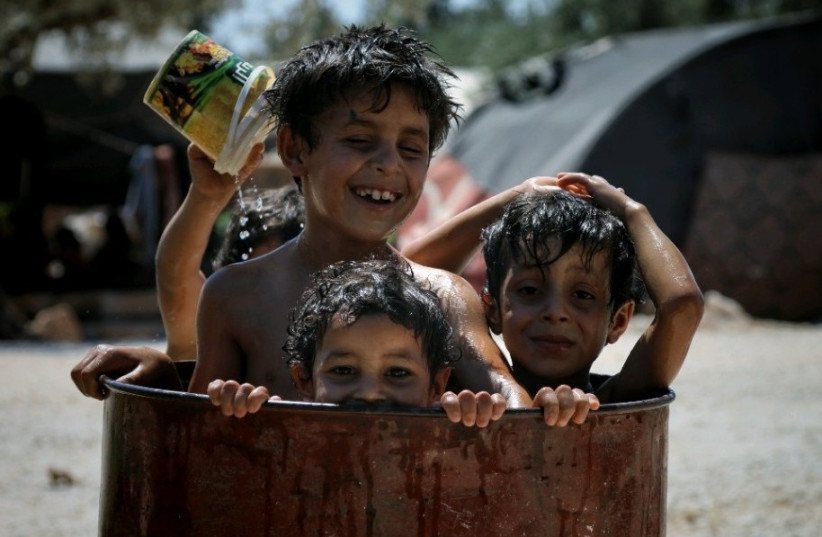  Children cool off in a refugee camp in Idlib, Syria in 2022. (credit: HIBA BARAKAT/THE MEDIA LINE)