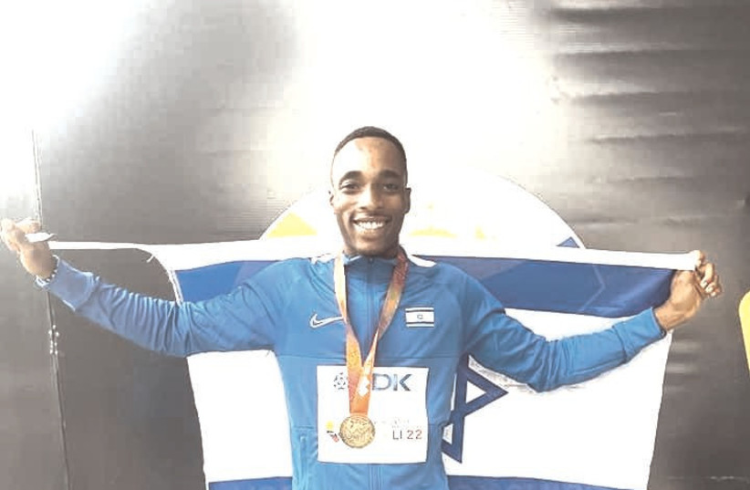 BLESSING AFRIFAH poses with his gold medal and draped with an Israeli flag after winning the 200m event at the U20 World Athletics Championships. (credit: Israel Athletic Association)