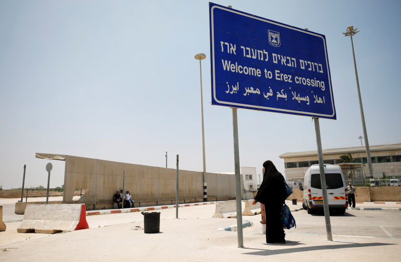  A Palestinian woman stands beneath a sign at the Israeli side of Erez crossing, on the border with Gaza June 23, 2019. (photo credit: AMIR COHEN/REUTERS)