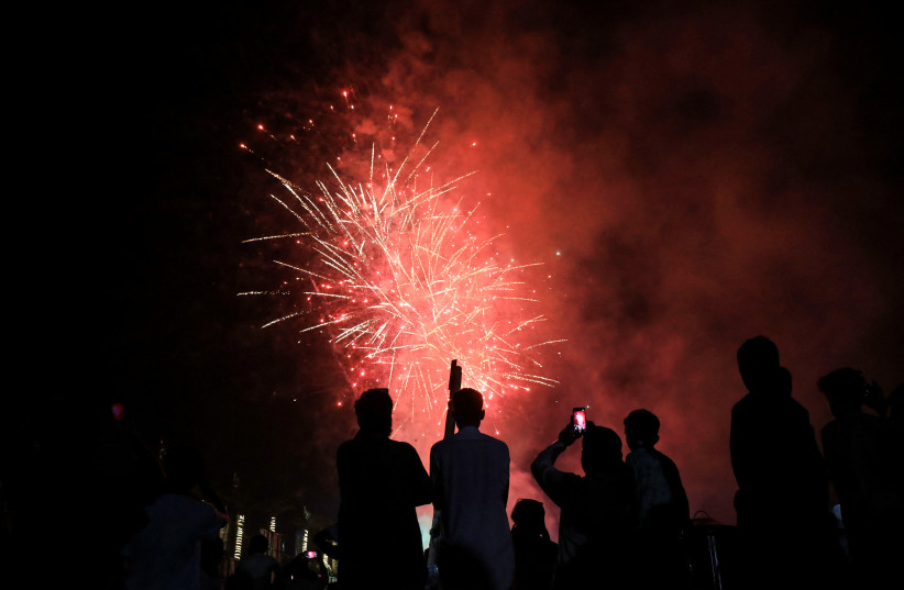 People are silhouetted as fireworks explode to celebrate on the eve of Pakistan's 75th Independence Day, in Peshawar, Pakistan, August 13, 2022. (credit: REUTERS/FAYAZ AZIZ)