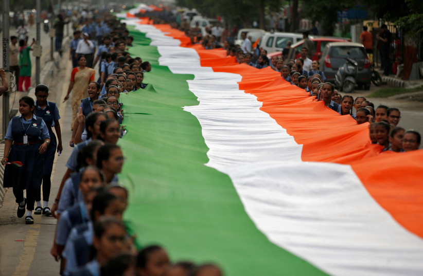  Students hold a giant Indian national flag during a "Tiranga Yatra" rally as part of the ongoing celebrations commemorating 75 years of India's Independence, in Ahmedabad, India, August 8, 2022. (photo credit: REUTERS/AMIT DAVE)
