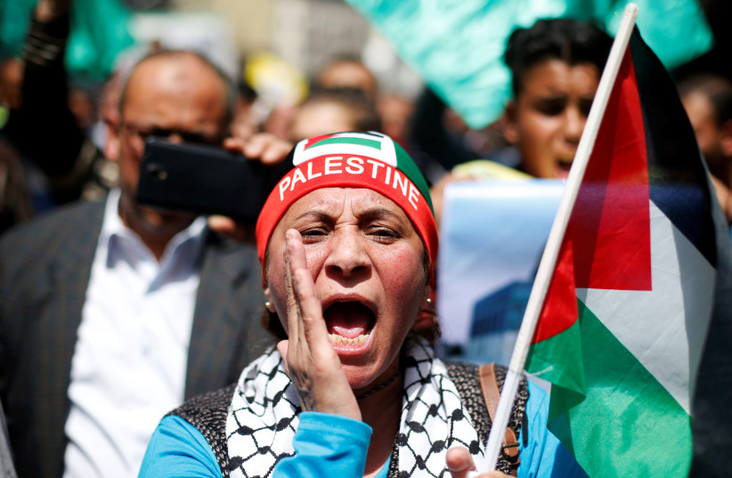  A supporter of the Muslim Brotherhood holds a Palestinian flag and chants slogans during a pro-Palestinian demonstration after Friday prayers in Amman, Jordan, April 13, 2018. (photo credit: REUTERS/MUHAMMAD HAMED)