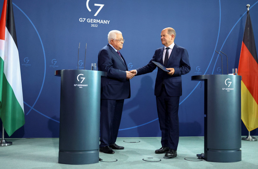  German Chancellor Olaf Scholz and Palestinian President Mahmoud Abbas shake hands as they attend a news conference, in Berlin, Germany, August 16, 2022 (photo credit: REUTERS/LISI NIESNER)