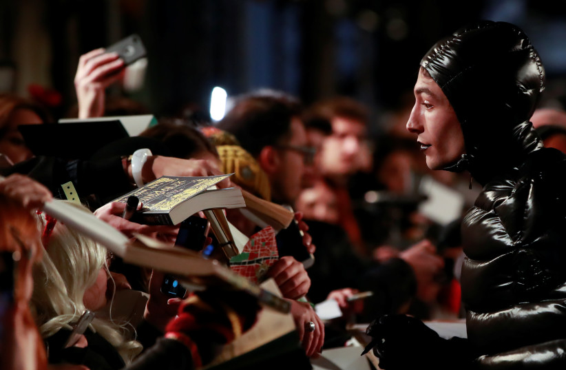Actor Ezra Miller signs autographs as he arrives for a photocall for the world premiere of the film ''Fantastic Beasts: The Crimes of Grindelwald'' in Paris, France, November 8, 2018.  (credit: REUTERS/GONZALO FUENTES)