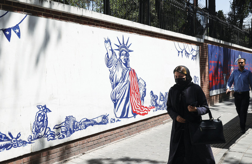  AN IRANIAN woman walks past a wall of the former US Embassy with an anti-America mural on it (photo credit: MAJID ASGARIPOUR/WANA/REUTERS)