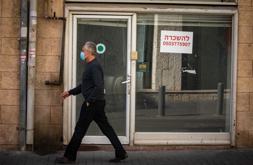  A man walks past a closed shop displaying a sign ''for rent'' in Jerusalem on January 11, 2021 (credit: OLIVIER FITOUSSI/FLASH90)