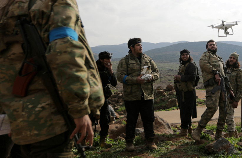 Turkish-backed Free Syrian Army fighters fly a drone in Northern Afrin countryside, Syria, February 15, 2018. (photo credit: REUTERS/KHALIL ASHAWI)