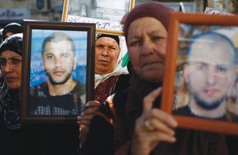  PALESTINIANS HOLD pictures of prisoners during a demonstration in Ramallah in support of prisoners on hunger strike in Israeli jails, 2014.  (photo credit: MOHAMAD TOROKMAN/REUTERS)