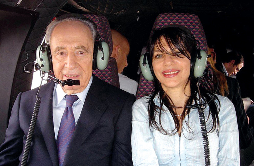  Bartal with Shimon Peres in a helicopter (private collection). (credit: YONA BARTAL)