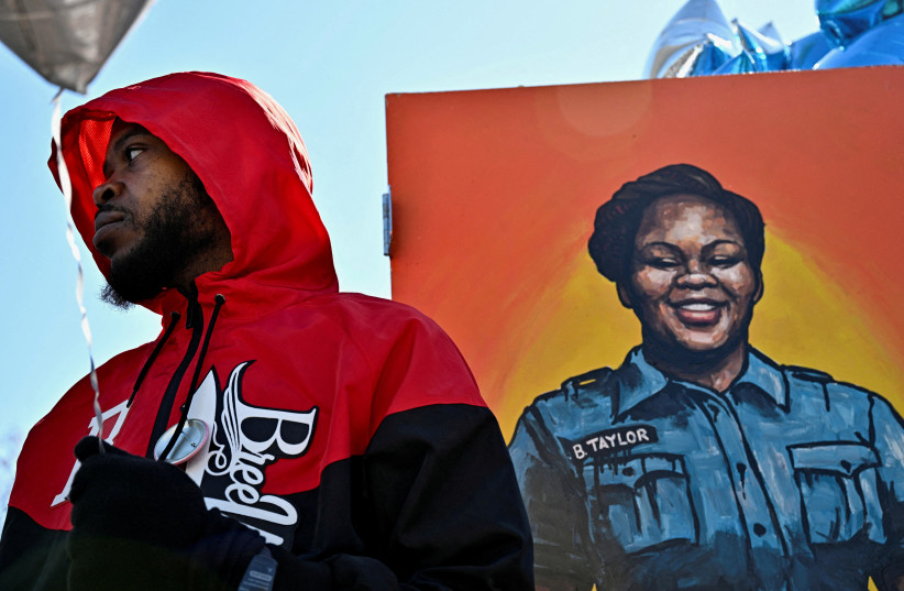  FILE PHOTO: Kenneth Walker III, the boyfriend of Breonna Taylor, stands next to a painting of her at a gathering to mark two years since police officers shot and killed Breonna Taylor when they entered her home, at Jefferson Square Park in Louisville, Kentucky, U.S., March 13, 2022.  (credit: REUTERS/Jon Cherry/File Photo)