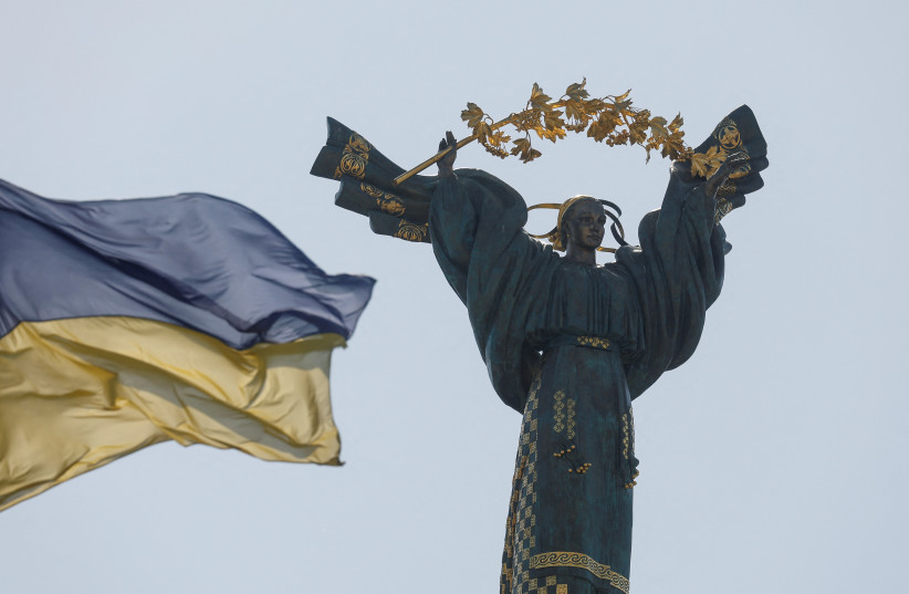  A Ukrainian national flag waves in front of the Independence Monument in the centre of Kyiv, as Russia's attack on Ukraine continues, Ukraine August 24, 2022.  (credit: REUTERS/VALENTYN OGIRENKO)