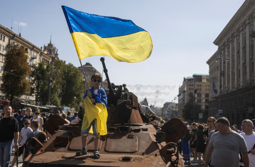  A boy waves a national flag atop of armoured personal carrier at an exhibition of destroyed Russian military vehicles and weapons, dedicated to the upcoming country's Independence Day, amid Russia's attack on Ukraine, in the centre of Kyiv, Ukraine August 21, 2022.  (credit: REUTERS/VALENTYN OGIRENKO)