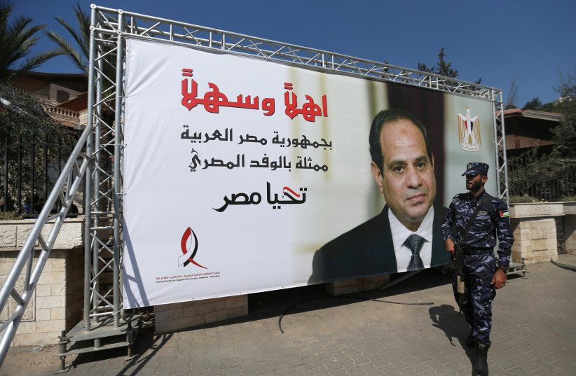  A Palestinian member of Hamas security forces stands guards next to a poster depicting Egypt's President Abdel Fattah al-Sisi, outside the Palestinian cabinet headquarters in Gaza City, October 3, 2017. (credit: REUTERS/IBRAHEEM ABU MUSTAFA)