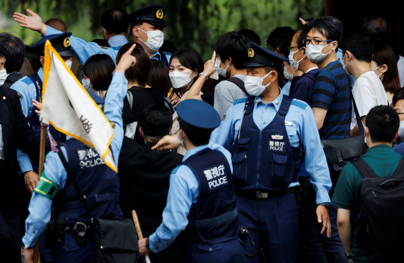  Police officers try to control the crowd of people in front of Zojoji temple where the funeral of the late former Japanese Prime Minister Shinzo Abe, who was shot while campaigning for a parliamentary election, will be held in Tokyo, Japan July 12, 2022. (photo credit: REUTERS/ISSEI KATO)