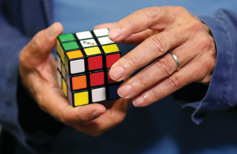  ERNO RUBIK, creator of the puzzle, solves a Rubik’s cube. The author describes Midrash as having the complexity of a Rubik’s cube. (photo credit: Stephane Mahe/Reuters)