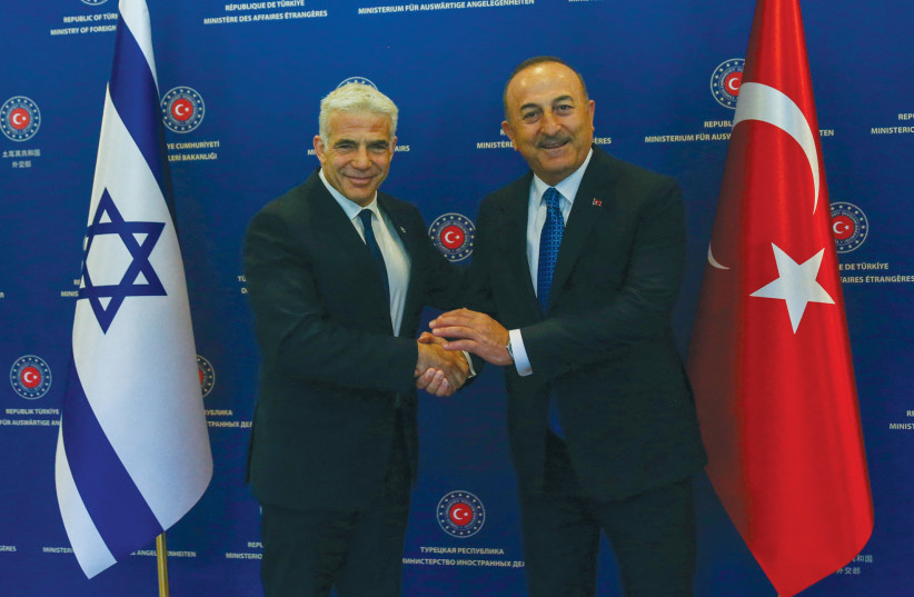  YAIR LAPID, then serving as foreign minister, shakes hands with Turkish Foreign Minister Mevlut Cavusoglu in Ankara in June.  (photo credit: NECATI SAVAS/REUTERS)