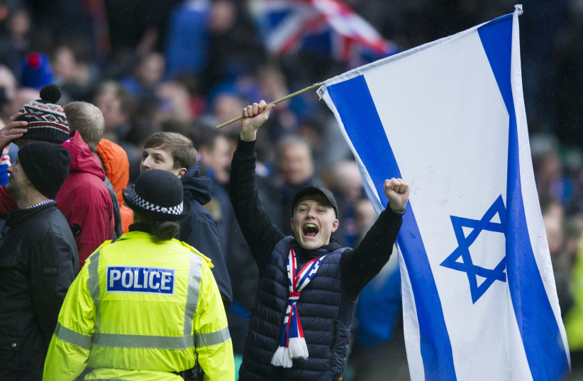  A Rangers FC fan celebrates while holding an Israeli flag during a match against Celtic FC in 2017.  (credit: Ross MacDonald/SNS Group via Getty Images)
