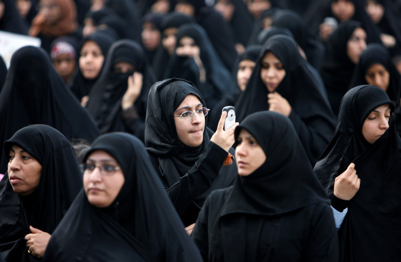  A Bahraini woman uses her mobile phone to take pictures during a demonstration in Manama, Bahrain. (credit: REUTERS/AHMED JADALLAH)