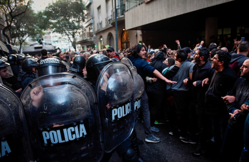  Supporters face police officers as they gather outside the house of Argentina's Vice President Cristina Fernandez de Kirchner, days after Fernandez was accused in a corruption case, in Buenos Aires, Argentina, August 27, 2022.  (credit: MARIANA NEDELCU/REUTERS)