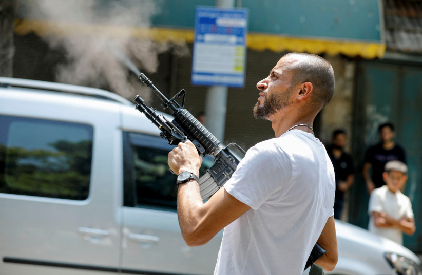 A Palestinian gunman fires a weapon in the air during the funeral of Ibrahim al-Nabulsi, a senior commander of the Fatah's Al-Aqsa Martyrs Brigades who was killed in armed clashes with Israeli forces, in Nablus in the West Bank August 9, 2022.  (photo credit: REUTERS/RANEEN SAWAFTA)