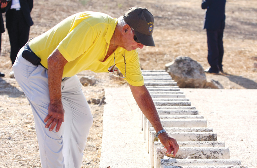  YANKELE HILLEL, a survivor of the 1929 Hebron massacre, places a stone on a grave amid a long row of small headstones for the victims, at a cemetery in the city, August 2009, marking 80 years since the massacre.  (photo credit: ABIR SULTAN/FLASH90)