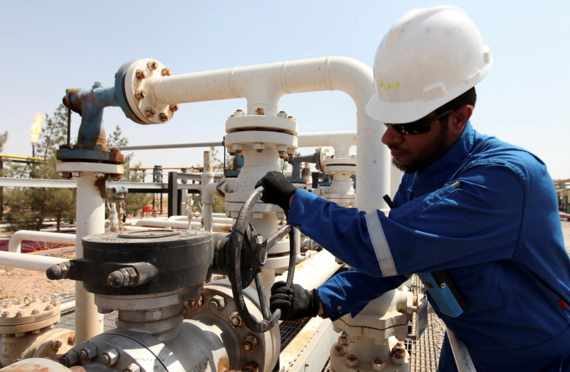 A worker adjusts a valve of an oil pipe at the Taq Taq oilfield in Erbil, in Iraq's Kurdistan region, August 16, 2014.  (photo credit: AZAD LASHKARI/REUTERS)