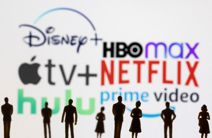  Toy figures of people are seen in front of the displayed Disney +, HBO Max, Apple TV, Netflix, Hulu and Prime video logos, in this illustration taken January 20, 2022.  (credit: REUTERS/DADO RUVIC/ILLUSTRATION)