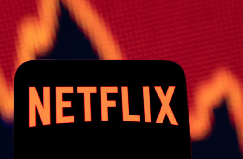  Smartphone with Netflix logo is seen in front of a stock graph in this illustration taken April 19, 2022. (photo credit: REUTERS/DADO RUVIC/ILLUSTRATION)