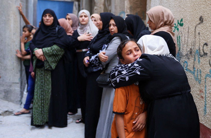  A woman comforts a child as mourners take part in the funeral of four teenage Palestinian cousins of Najim family, who were killed amid Israel-Gaza fighting, as a ceasefire holds, in Jabaliya, in the northern Gaza Strip, August 8, 2022. (photo credit: SUHAIB SALEM/REUTERS)