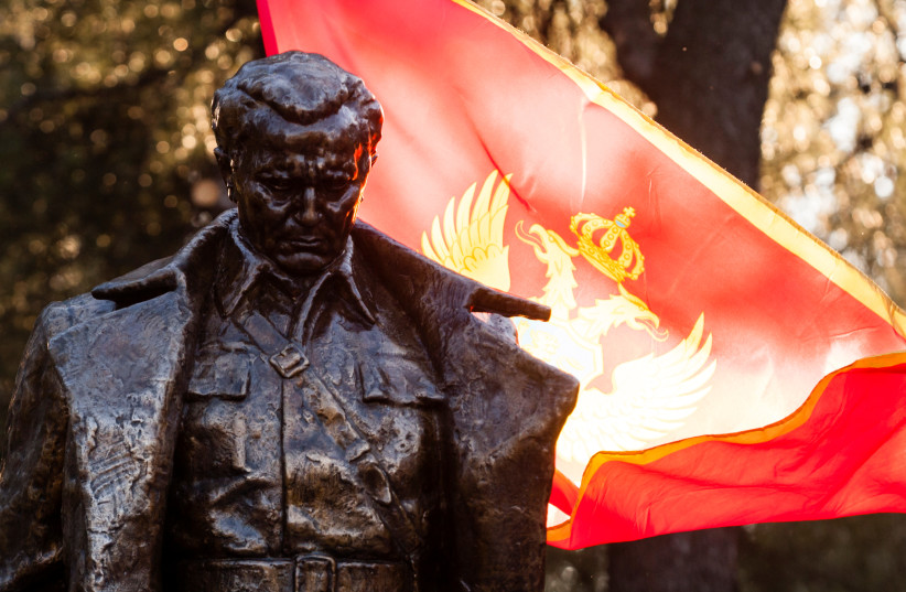  Montenegrian flag wave behind the monument of late Yugoslav leader Josip Broz Tito after unveiling ceremony in Podgorica, Montenegro, December 19, 2018 (credit: STEVO VASILJEVIC/REUTERS)