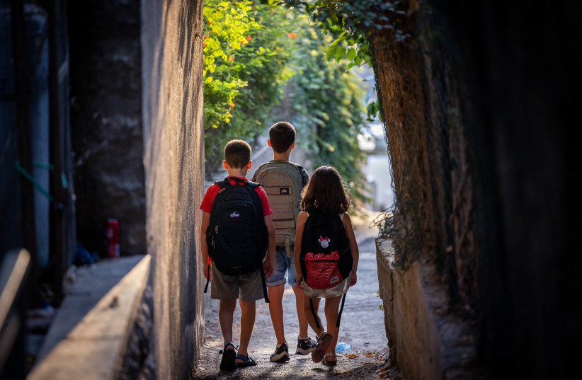  Israeli kids wearing school bags ahead of the first day of school outside thier home in Jerusalem on August 31, 2022, The Israeli secular state education system will open tomorrow.  (credit: YONATAN SINDEL/FLASH90)