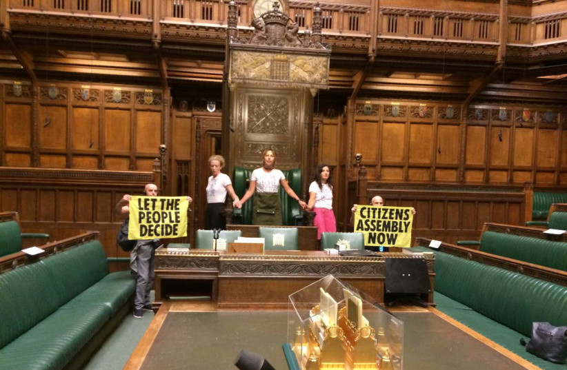  Extinction Rebellion activists protest inside the House of Commons in London, Britain September 2, 2022 in this picture obtained from social media. (photo credit: Extinction Rebellion UK/via REUTERS)
