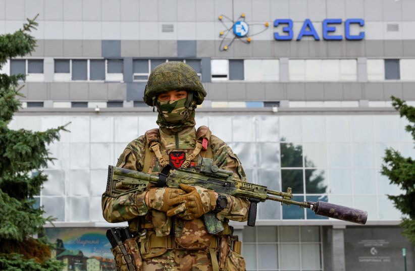  A service member stands guard near the Russian-controlled Zaporizhzhia Nuclear Power Plant following the arrival of the International Atomic Energy Agency (IAEA) expert mission in the course of Ukraine-Russia conflict outside Enerhodar in the Zaporizhzhia region, Ukraine, September 1, 2022.  (credit: REUTERS/ALEXANDER ERMOCHENKO)