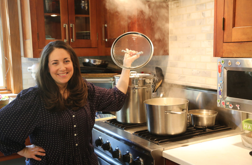  Shannon Sarna, author of "Modern Jewish Comfort Food," stands over a pot of chicken soup, one of the many comfort food recipes in her new book.  (photo credit: Doug Schneider)