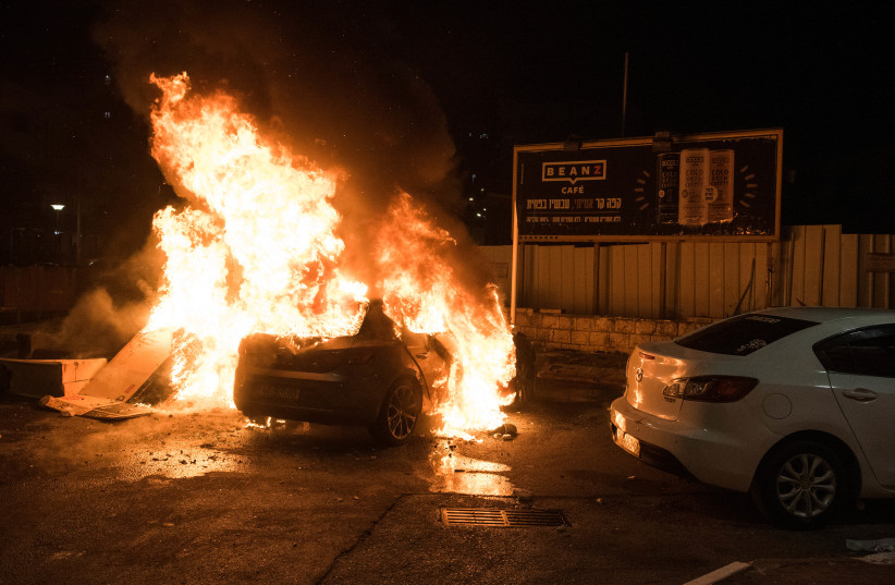  A car is set on fire during clashes between Arab and Jews in Acre, northern Israel, May 12, 2021 (photo credit: RONI OFER/FLASH90)