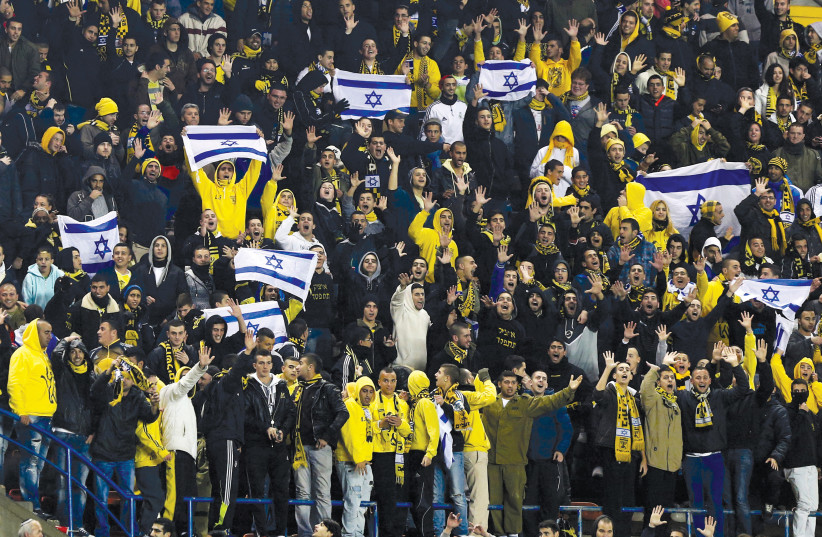  Beitar Jerusalem fans cheer their team during a match against Maccabi Umm el-Fahm at Teddy Stadium in Jerusalem. (photo credit: NIR ELIAS/REUTERS)