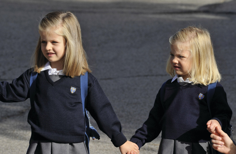  TWO YOUNG Spanish girls walk hand in hand to school.  (photo credit: Carlos Alvarez/Getty Images)