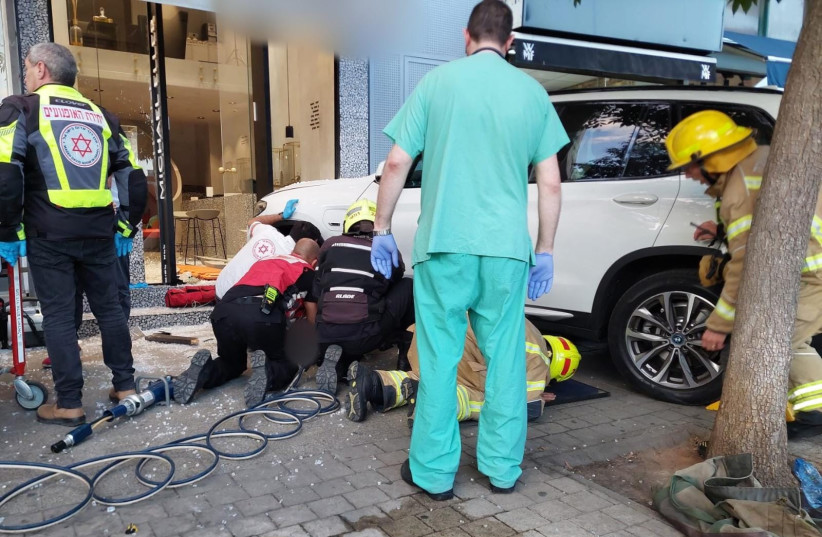  MDA medics and firefighters rescuing people trapped under a car that hit 4 pedestrians in Tel Aviv (photo credit: MDA OPERATIONAL COVERAGE)