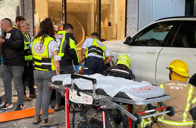  MDA medics and firefighters rescuing people trapped under a car that hit 4 pedestrians in Tel Aviv (credit: MDA OPERATIONAL COVERAGE)