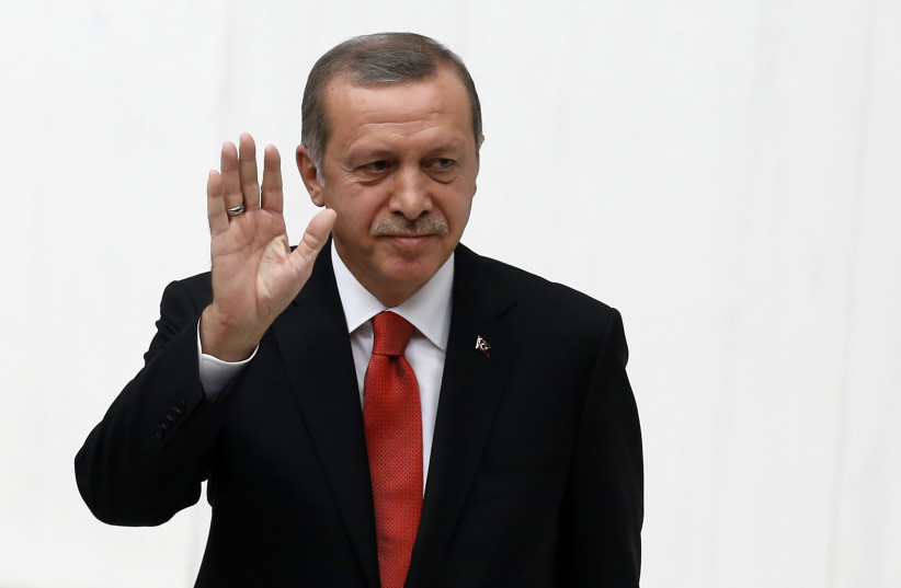 Turkey's President Tayyip Erdogan waves as he attends a debate marking the reconvene of the parliament after a summer recess at the Turkish Parliament in Ankara, October 1, 2014. (photo credit: REUTERS/UMIT BEKTAS)