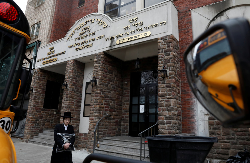 An Orthodox Jewish man walks by the Yeshiva Kehilath Yakov school on the day New York City Mayor Bill de Blasio declared a public health emergency in parts of Brooklyn in response to a measles outbreak in New York City, US, April 9, 2019. (credit: REUTERS/SHANNON STAPLETON)