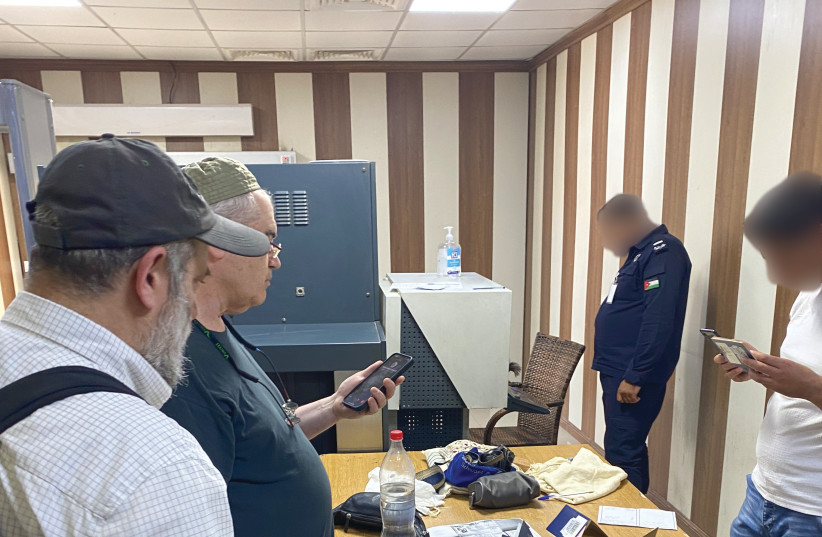  THE WRITERS undergo a security check at the border crossing by Jordanian personnel (faces blurred), with the religious items placed on the table.  (photo credit: Zvi Schwartz)