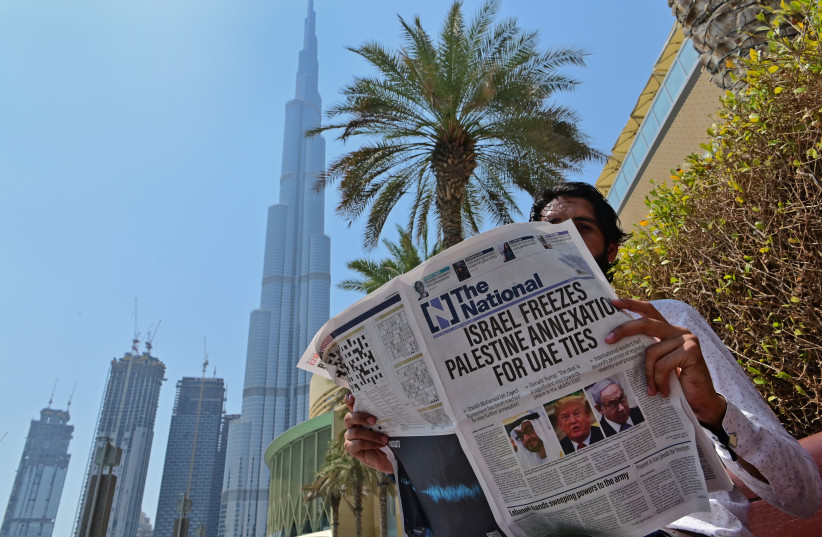  READING UAE-BASED ‘The National’ newspaper near Dubai’s Burj Khalifa, 2020.  (credit: Giuseppe Cacace/AFP via Getty Images)