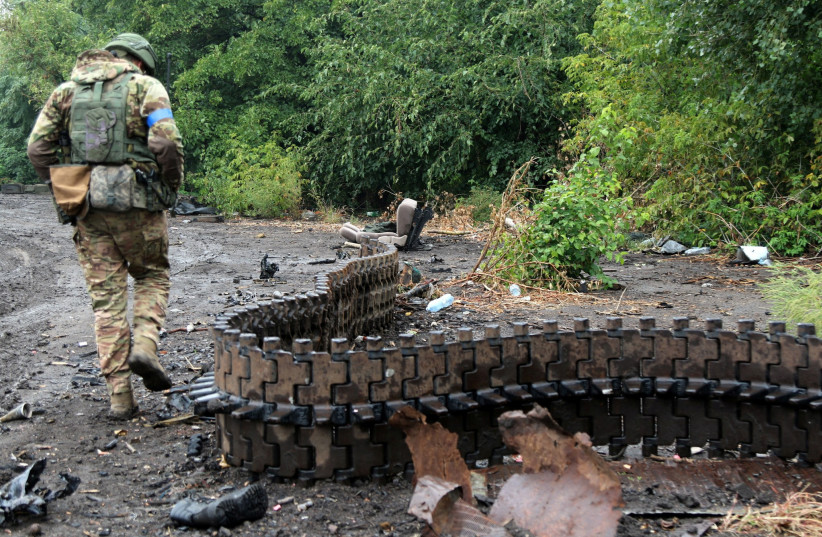 A Ukrainian service member inspects a continuous track of a Russian tank destroyed during a counteroffensive operation of the Ukrainian Armed Forces, amid Russia's attack on Ukraine, in Kharkiv region, Ukraine, September 14, 2022. (credit: PRESS SERVICE OF THE 30TH INDEPENDENT MECHANIZED BRIGADE OF THE UKRAINIAN ARMED FORCES/VIA REUTERS)